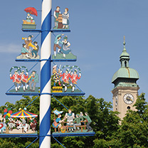 Ein Maibaum vor einem Kirchturm